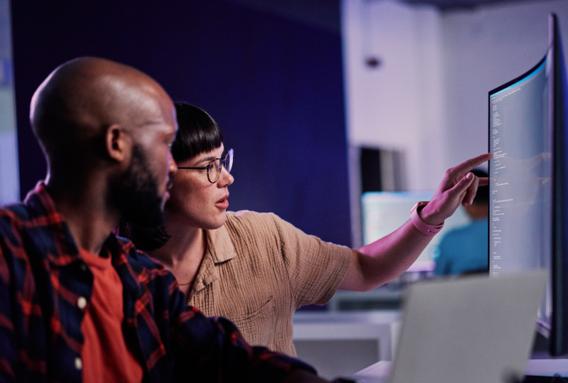 man and woman discussing data displayed on a monitor