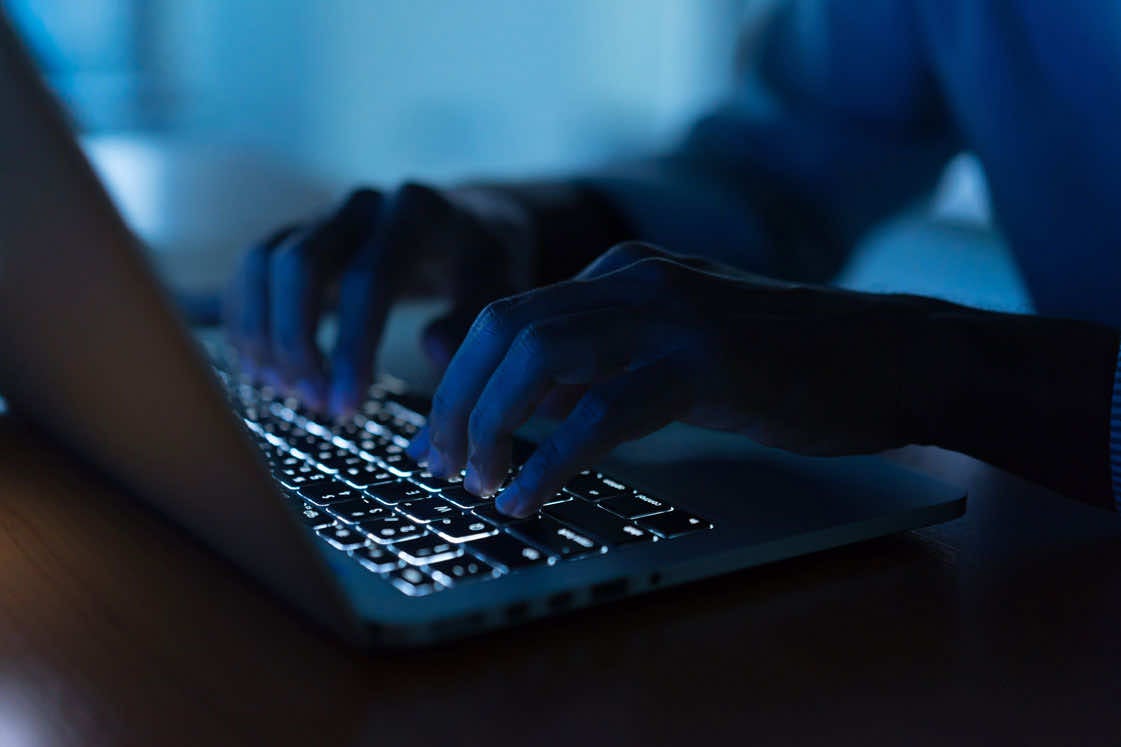 man typing on a laptop